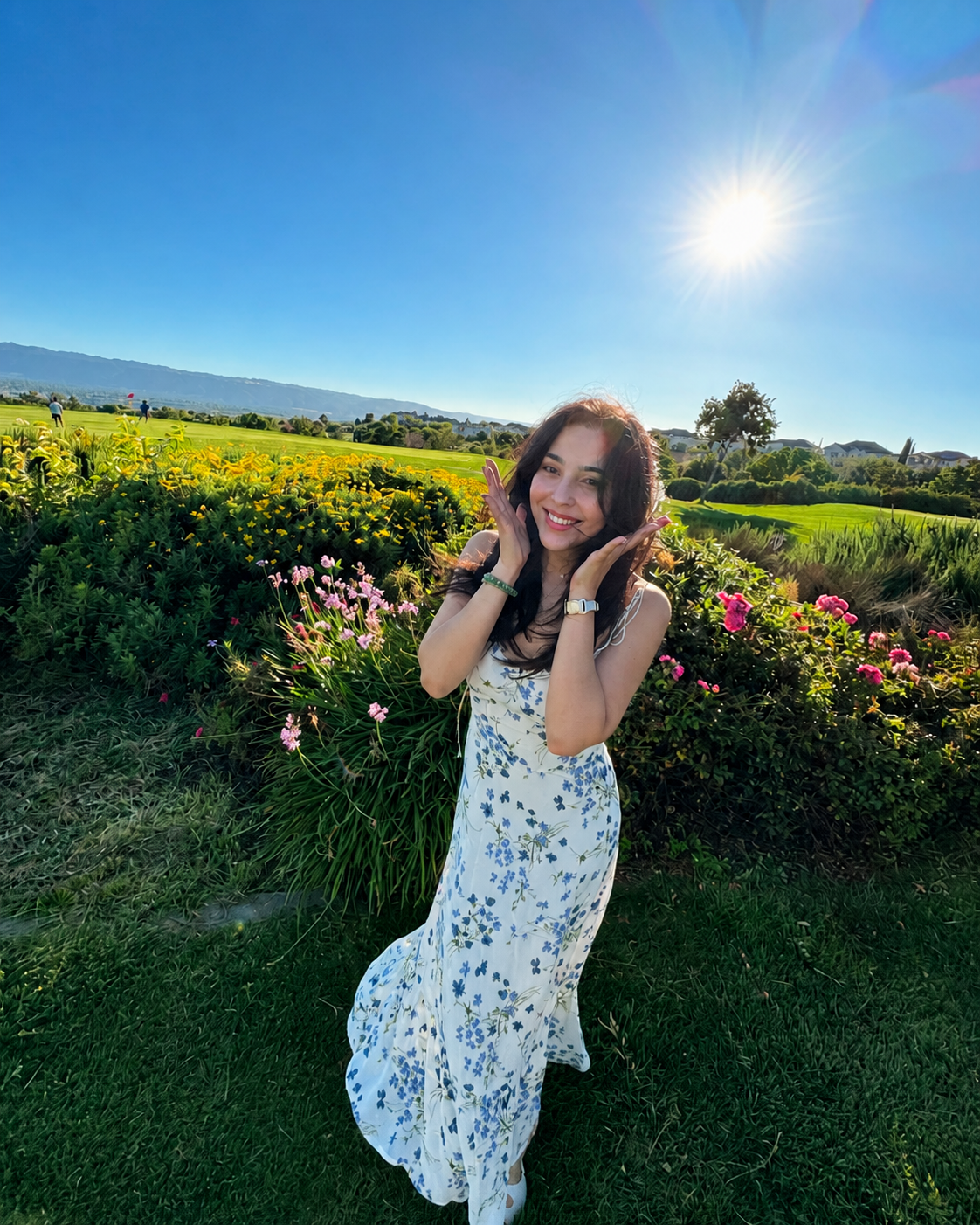 Shaha Hone smiling in a flower garden